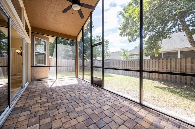 unfurnished sunroom featuring a ceiling fan