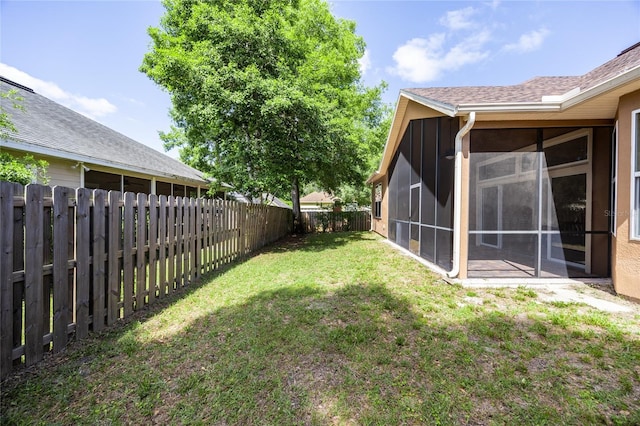 view of yard with a fenced backyard and a sunroom