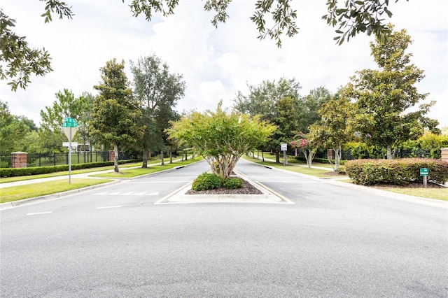 view of road with sidewalks, traffic signs, and curbs