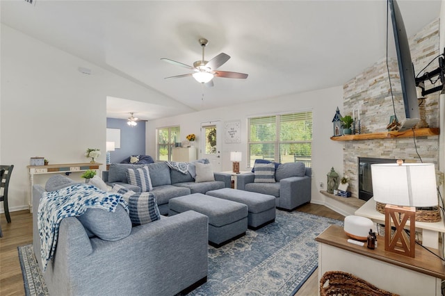 living area featuring wood finished floors, a fireplace, baseboards, ceiling fan, and vaulted ceiling
