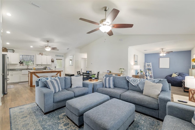 living area with recessed lighting, ceiling fan, lofted ceiling, and light wood-type flooring