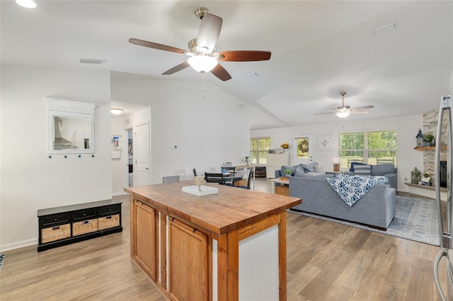 kitchen featuring visible vents, wood counters, a ceiling fan, light wood-type flooring, and vaulted ceiling