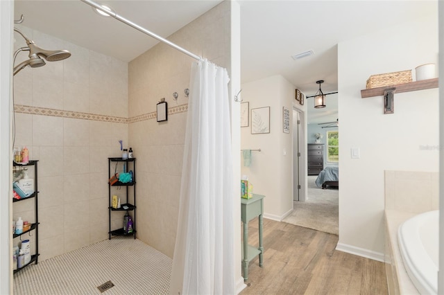 ensuite bathroom featuring a bath, visible vents, wood finished floors, ensuite bath, and tiled shower