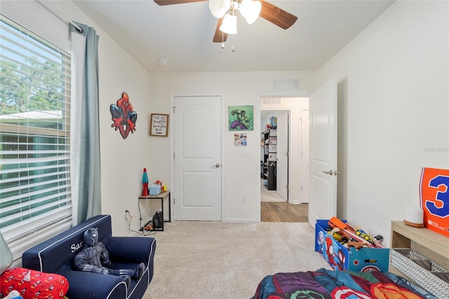 recreation room with visible vents, carpet flooring, and ceiling fan