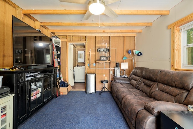 carpeted living area with ceiling fan and beamed ceiling