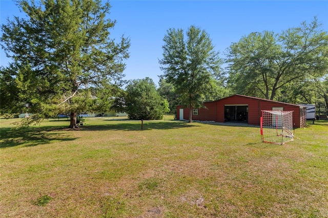 view of yard with a detached garage, an outbuilding, and an outdoor structure