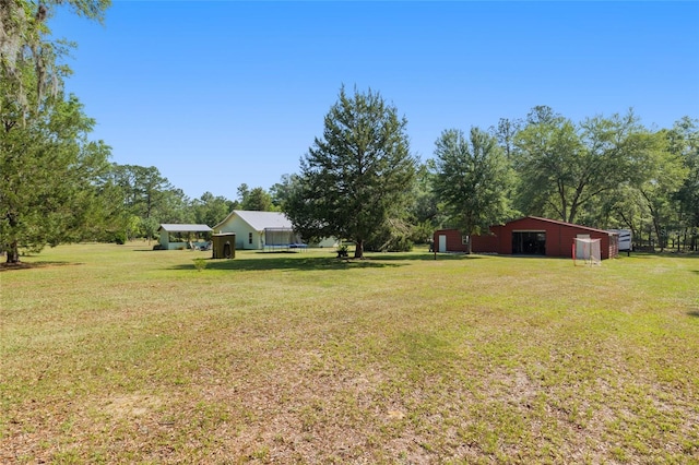 view of yard featuring a detached garage and an outbuilding