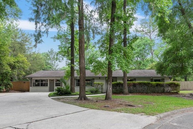 single story home featuring fence and concrete driveway