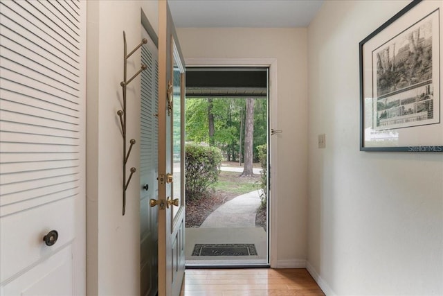 doorway to outside featuring visible vents, light wood finished floors, and baseboards