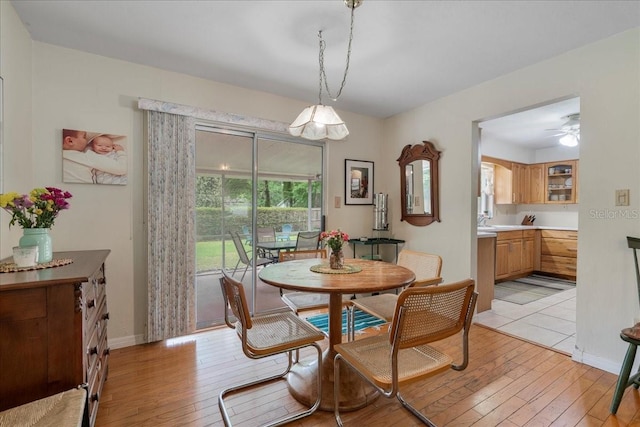 dining room featuring light wood-style floors, baseboards, and a ceiling fan