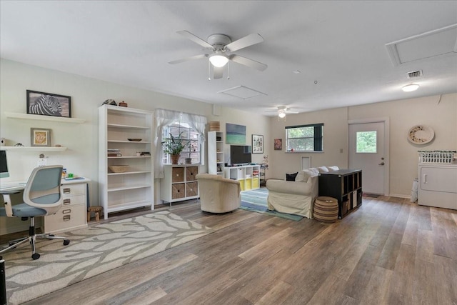 living area featuring a ceiling fan, attic access, washer / clothes dryer, and visible vents
