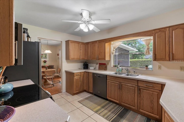 kitchen featuring a sink, light tile patterned flooring, light countertops, a ceiling fan, and appliances with stainless steel finishes