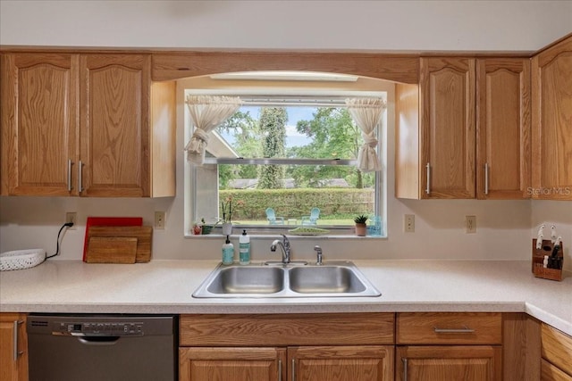 kitchen featuring brown cabinetry, a sink, dishwasher, and light countertops