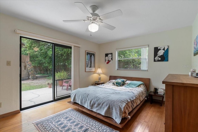 bedroom featuring multiple windows, a ceiling fan, hardwood / wood-style flooring, and access to exterior