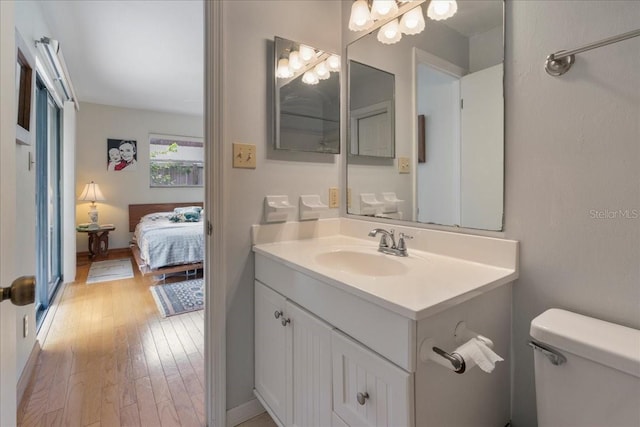 bathroom featuring vanity, ensuite bath, toilet, and hardwood / wood-style floors