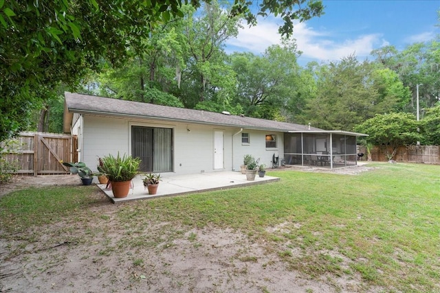 back of property featuring a fenced backyard, a yard, a patio, and a sunroom