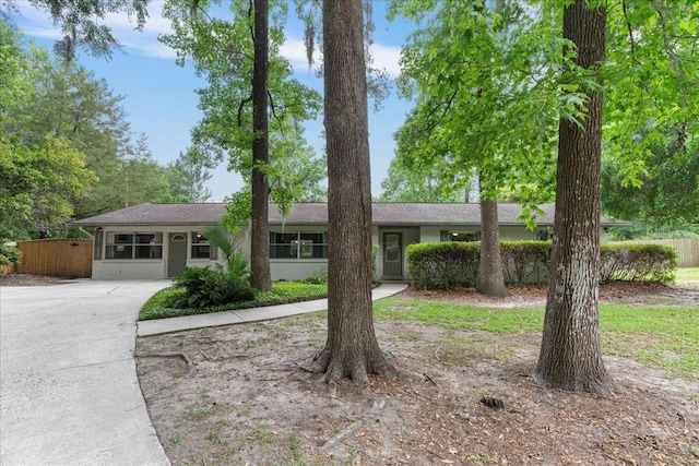 ranch-style house featuring fence and driveway