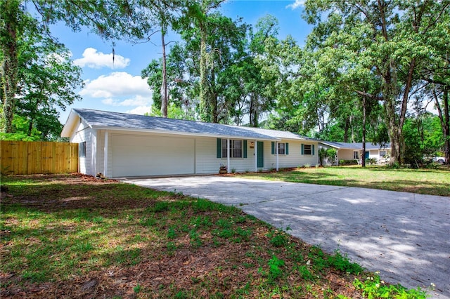 single story home featuring fence, an attached garage, driveway, and a front yard