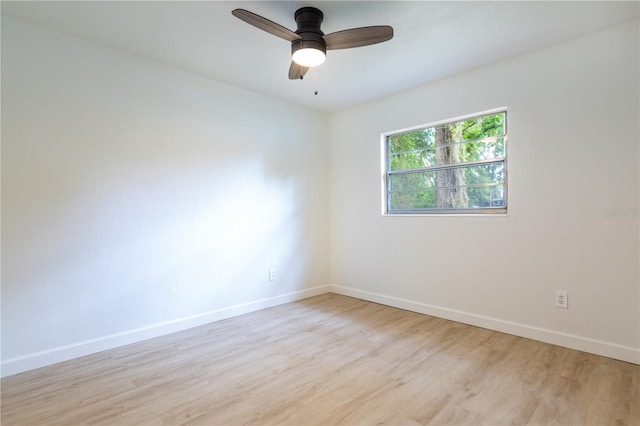 unfurnished room with light wood-type flooring, a ceiling fan, and baseboards
