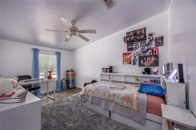 bedroom with baseboards, ceiling fan, visible vents, and wood finished floors