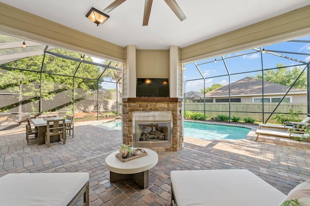 view of patio featuring fence, outdoor dining space, an outdoor stone fireplace, a fenced in pool, and a lanai