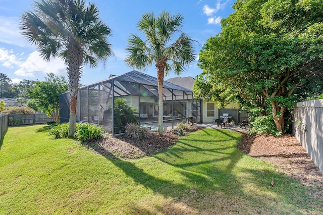 view of yard with a lanai, a fenced backyard, and a patio area