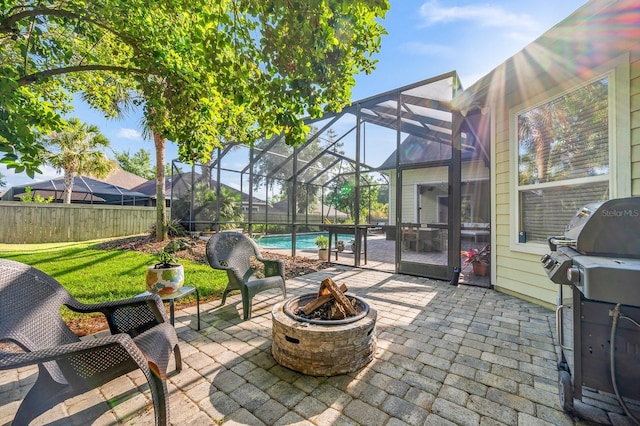 view of patio / terrace featuring fence, grilling area, a fenced in pool, an outdoor fire pit, and a lanai