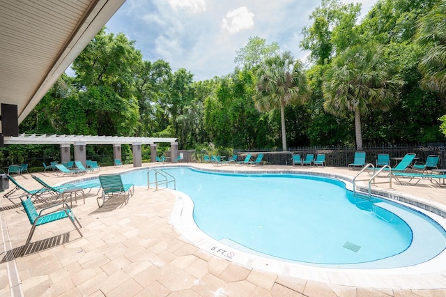 pool featuring a pergola, fence, and a patio area