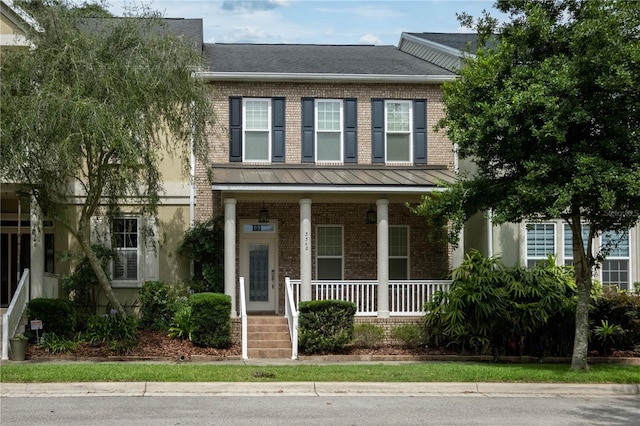 3540 SW 74th Way, Gainesville, FL 32608 - view of property with covered porch, brick siding, and roof with shingles