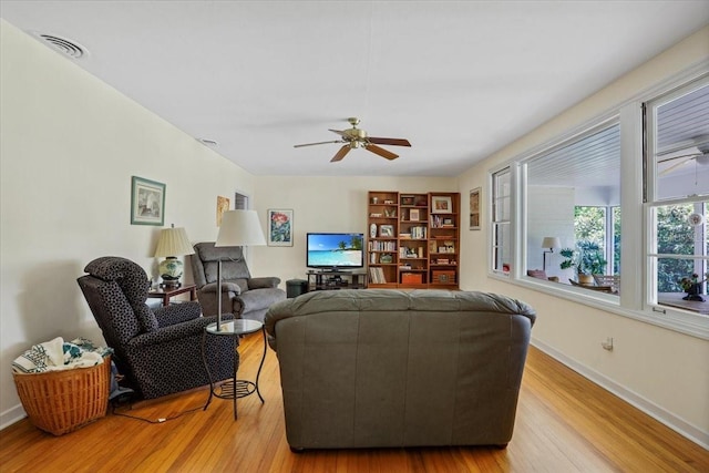 living room with baseboards, ceiling fan, visible vents, and wood finished floors