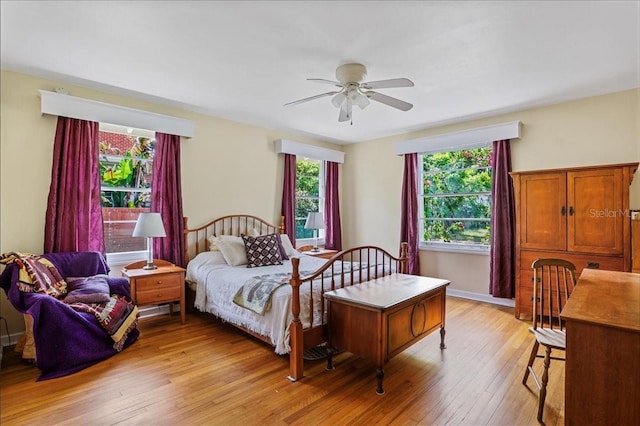 bedroom featuring light wood finished floors, ceiling fan, and multiple windows