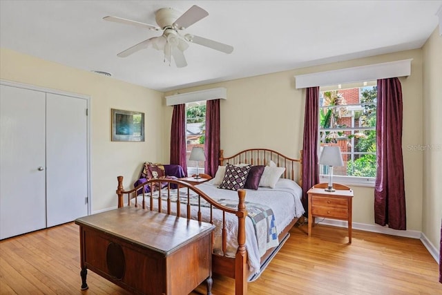 bedroom featuring baseboards, a ceiling fan, light wood-type flooring, and visible vents