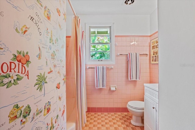 bathroom with a shower with curtain, tile walls, tile patterned floors, vanity, and toilet