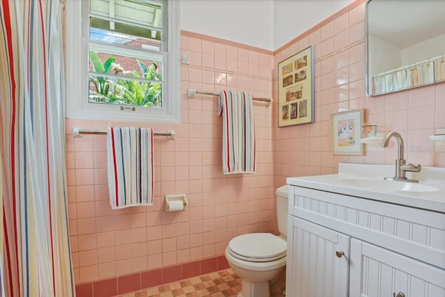 bathroom featuring tile walls, vanity, and toilet