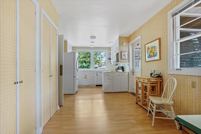 corridor featuring wallpapered walls and light wood-style flooring