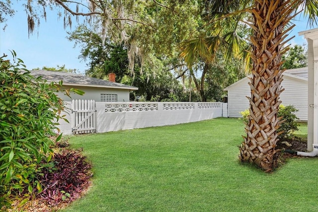 view of yard with a fenced backyard and a gate