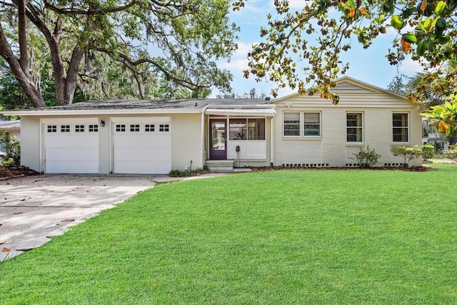 ranch-style home with a garage, entry steps, a front yard, and concrete driveway