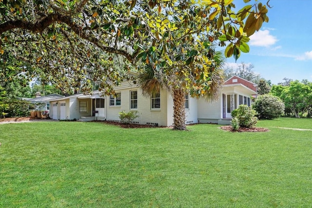 view of front of home with a front yard and a garage