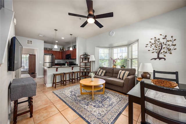 living room featuring light tile patterned floors, baseboards, ceiling fan, and visible vents