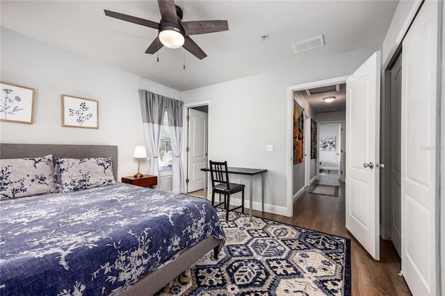 bedroom with attic access, a ceiling fan, baseboards, wood finished floors, and visible vents