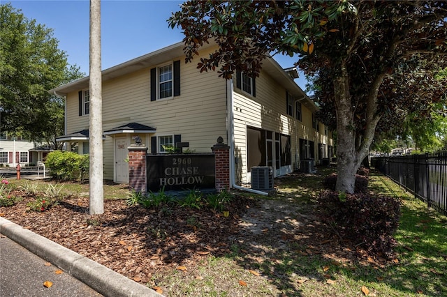 view of property exterior with fence and central AC unit
