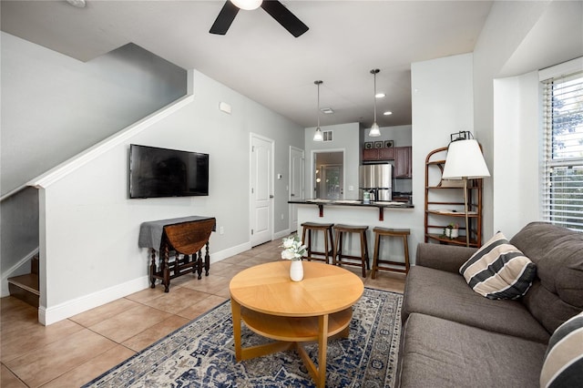 living room featuring ceiling fan, stairs, baseboards, light tile patterned floors, and visible vents