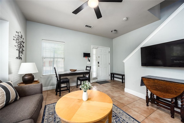 living room featuring baseboards, ceiling fan, visible vents, and light tile patterned floors