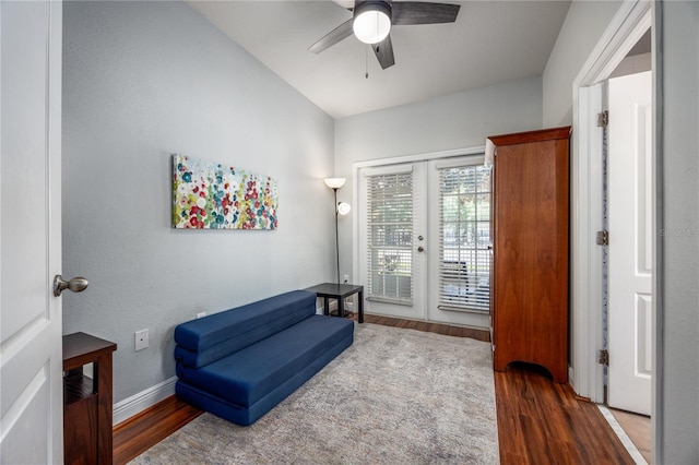 living area featuring baseboards, ceiling fan, and wood finished floors