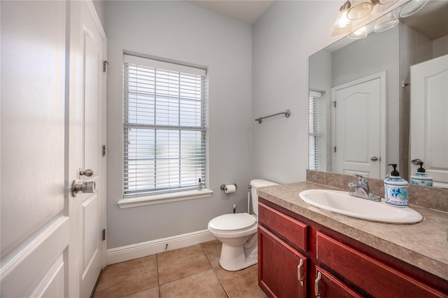 bathroom featuring toilet, baseboards, tile patterned flooring, and vanity