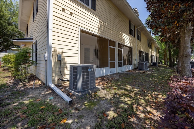view of side of property with central air condition unit and a sunroom