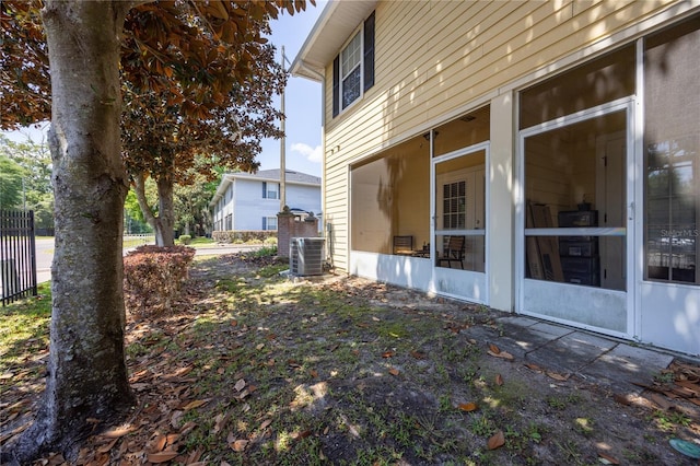 view of side of property featuring central air condition unit and a sunroom