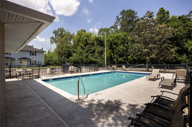 community pool featuring a patio area and fence