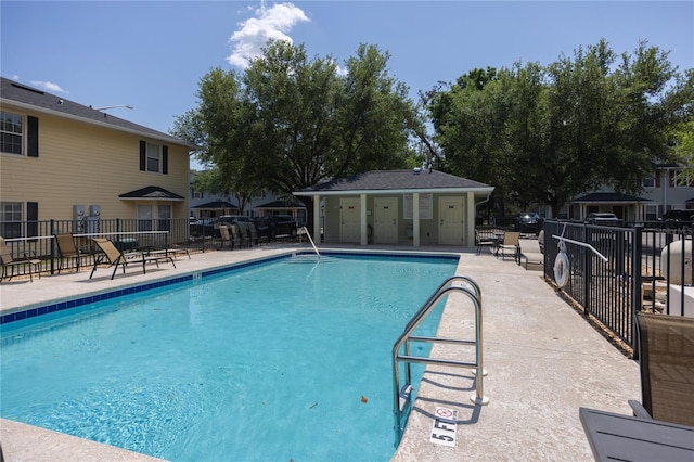 community pool with a patio and fence