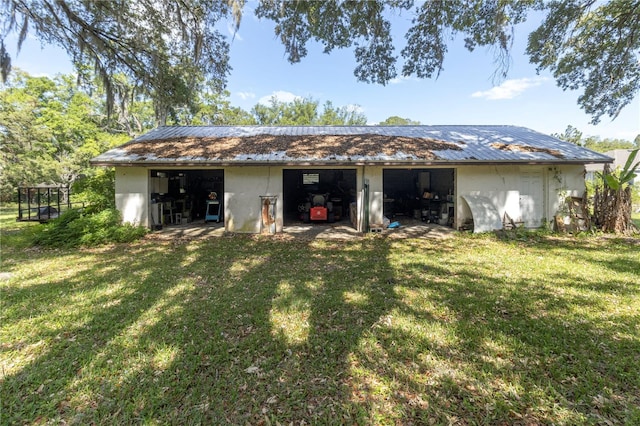 1529 NW 143rd St, Gainesville, FL 32606 - back of property featuring a yard, a garage, stucco siding, and an outbuilding